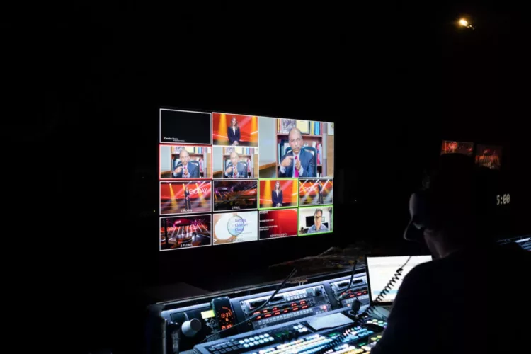 Een regiekamer met een monitor die verschillende videofeeds toont van een live-uitzending.
