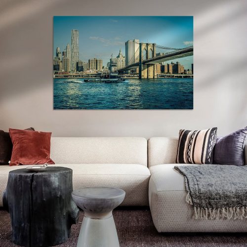 Uitzicht op de Brooklyn Bridge met de skyline van Manhattan op de achtergrond, weerspiegeld in het water.