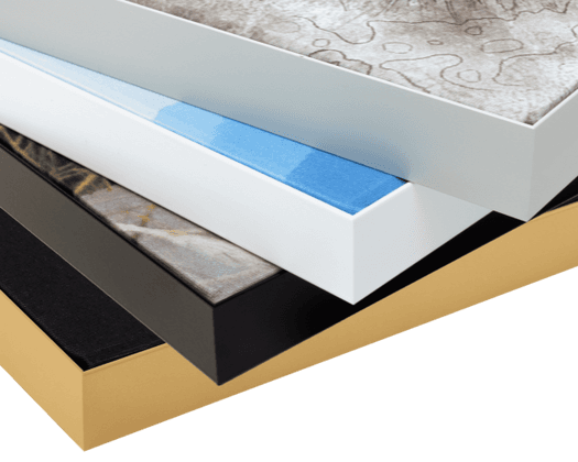Gestapelde canvas doeken in zwart, wit, blauw en goud met verschillende texturen en patronen.