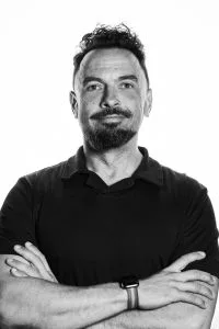 Portret van een man met gekruiste armen Zwart-wit portret van een man met een baard en gekruiste armen, kijkend naar de camera.